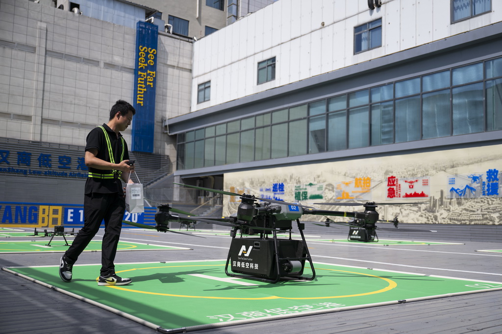6月16日，在汉商低空港停机坪，一名工作人员给无人机装配货物。
